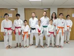 Instructor Simon Apen-Sadler and the studets wearing their new belts at the first class after grading